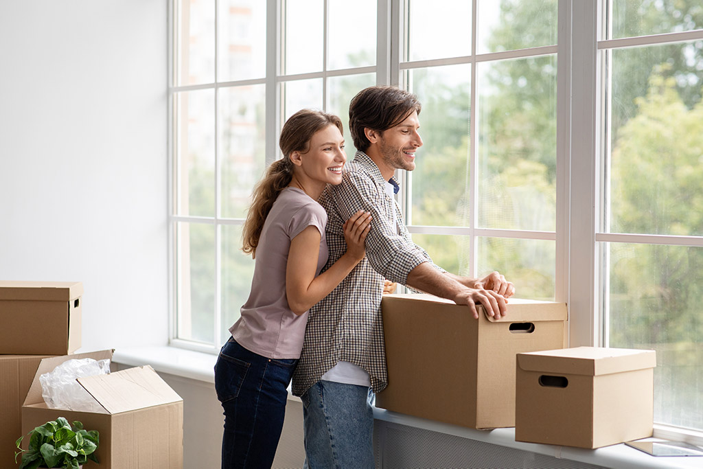 Man and woman laughing and looking out a window