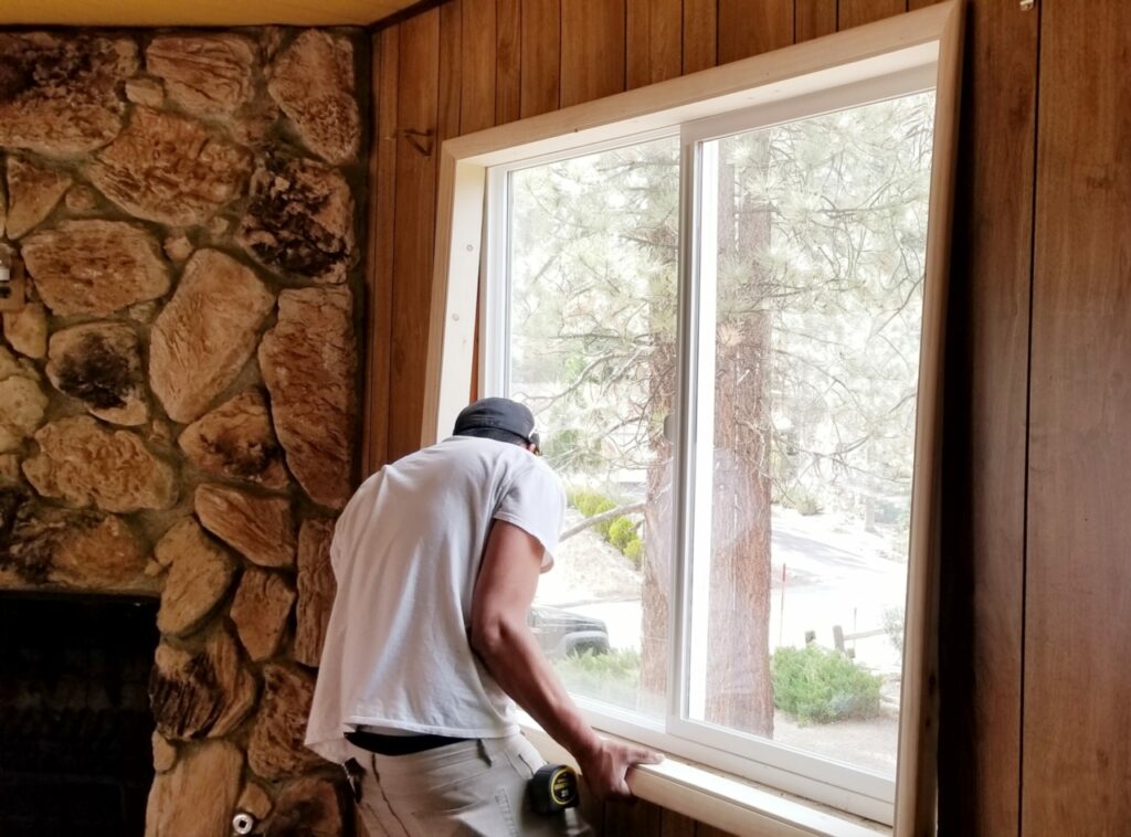 worker installing window for affordable home improvement