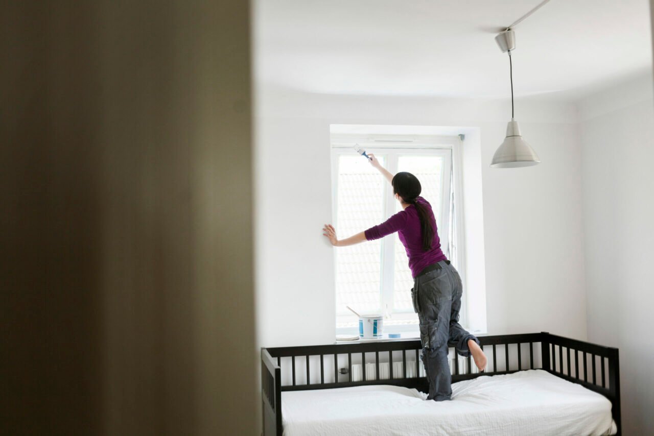 Woman painting vinyl windows