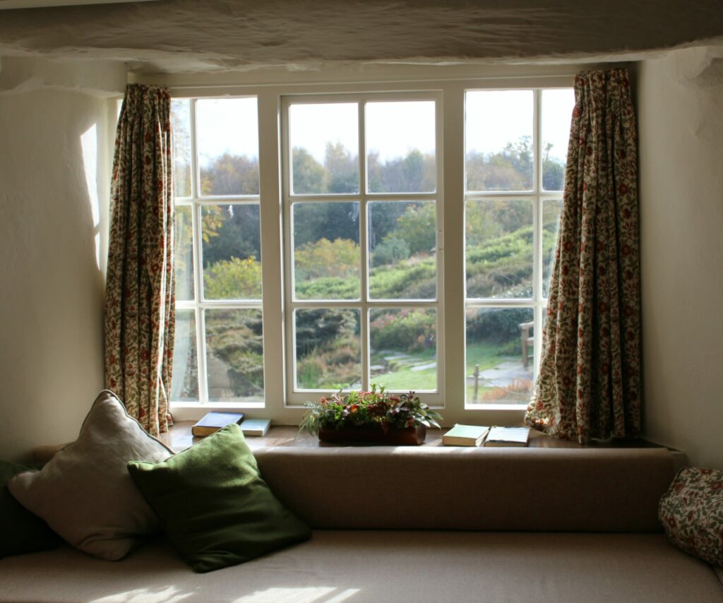 A view looking out from single-hung windows to a green forest